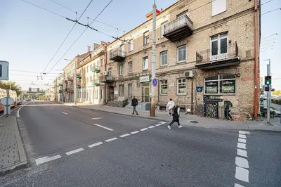 two people crossing the street in an empty street at Warm studio in the heart of city in Vilnius