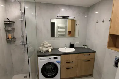 a bathroom with a washing machine and a sink at Warmzy Home - Modern 2 Rooms Apartment With Free Parking in Vilnius