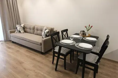 a living room with a table and a couch at Warmzy Home - Modern 2 Rooms Apartment With Free Parking in Vilnius