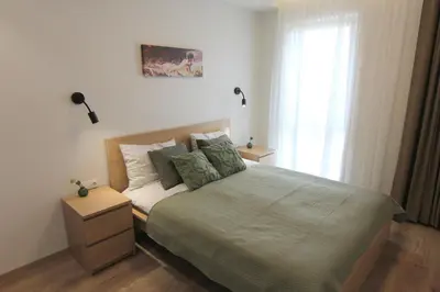 a bedroom with a large bed and a window at Warmzy Home - Modern 2 Rooms Apartment With Free Parking in Vilnius