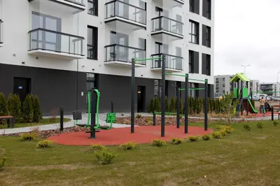 a playground in a park in front of a building at Warmzy Home - Modern 2 Rooms Apartment With Free Parking in Vilnius