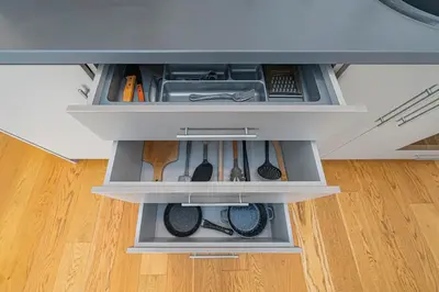 an open drawer with utensils in a kitchen at CityVibe apartment by Polo Apartments in Kaunas