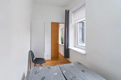 a bedroom with a bed and a chair in a room at CityVibe apartment by Polo Apartments in Kaunas