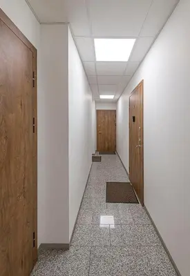 a hallway with wooden doors and a tile floor at UrbanLife Apartment by Polo Apartments in Kaunas