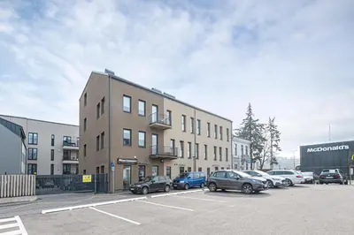 a parking lot with cars parked in front of a building at UrbanLife Apartment by Polo Apartments in Kaunas