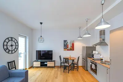 a kitchen and living room with a table and chairs at UrbanLife Apartment by Polo Apartments in Kaunas