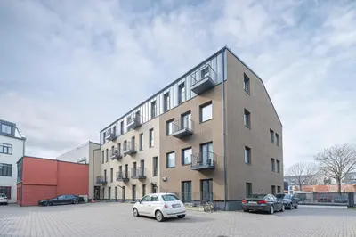 a building with cars parked in a parking lot at UrbanLife Apartment by Polo Apartments in Kaunas