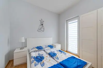 a white bedroom with a bed and a window at UrbanLife Apartment by Polo Apartments in Kaunas