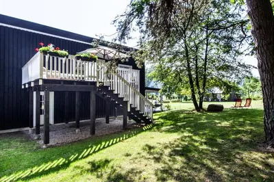 a house with a staircase with flowers on it at Pušyno apartamentai in Druskininkai