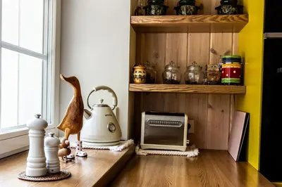 a kitchen with a table with a tea kettle and a toaster at Pušyno apartamentai in Druskininkai