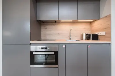 a kitchen with a sink and a stove at cohost I Trendy Apt w- Balcony & Garage Parking in Vilnius