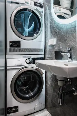 a washer and dryer next to a sink in a bathroom at cohost I Trendy Apt w- Balcony & Garage Parking in Vilnius