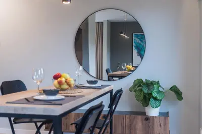 a dining room with a table with a mirror at cohost I Trendy Apt w- Balcony & Garage Parking in Vilnius