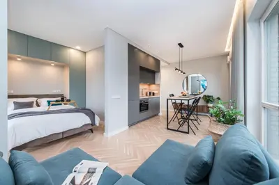 a bedroom with a bed and a living room at cohost I Trendy Apt w- Balcony & Garage Parking in Vilnius