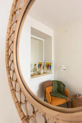 a mirror reflection of a chair in a living room at Homey apartment central in Vilnius