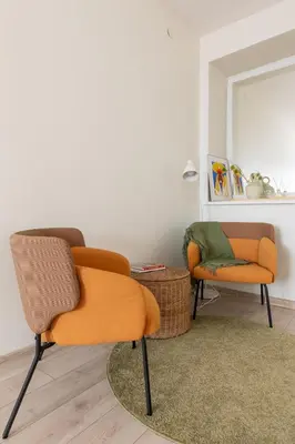 two chairs and a mirror in a living room at Homey apartment central in Vilnius