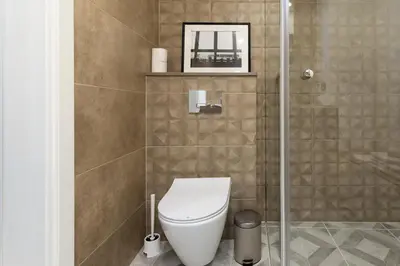 a bathroom with a toilet and a glass shower at Homey apartment central in Vilnius