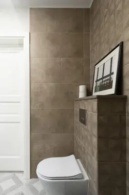 a bathroom with a toilet and a picture on a wall at Homey apartment central in Vilnius
