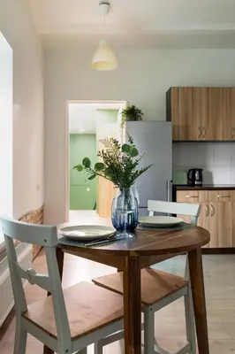 a dining room table with a vase of flowers on it at Homey apartment central in Vilnius