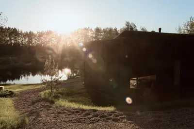 a house sitting on a dirt road next to a lake at Konga Stay L in Aluona