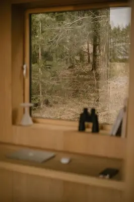 a window with a view of a forest seen through it at Konga Stay L in Aluona