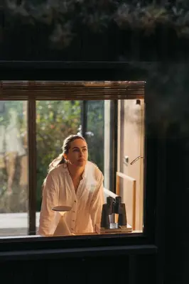 a woman is looking out of a window at Konga Stay L in Aluona