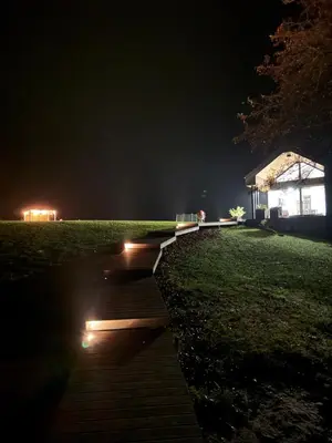 a walkway with lights on the grass at night at Panacea in Lazdijai