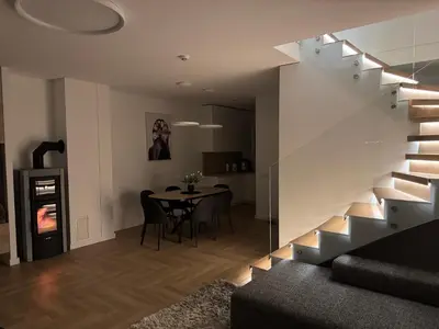 a living room with a staircase and a dining room table at Panacea in Lazdijai