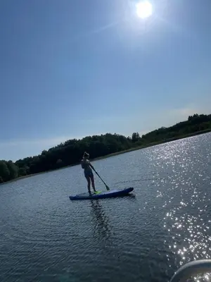 a person on a paddle board on a lake at Panacea in Lazdijai
