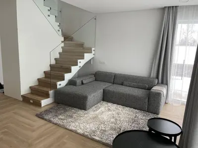 a living room with a couch and a staircase at Panacea in Lazdijai