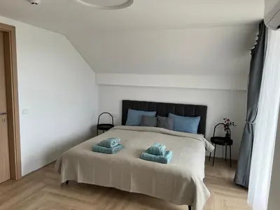 a bedroom with a bed with two blue pillows on it at Panacea in Lazdijai