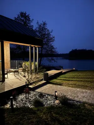 a pavilion with a dock next to a lake at Panacea in Lazdijai