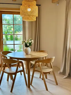 a dining room table with chairs and a vase of flowers at Poeto Namas Art in Anykščiai