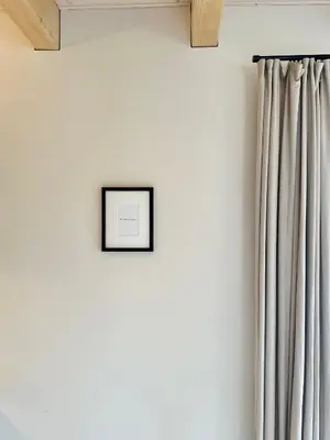 a picture frame on a wall next to a curtain at Poeto Namas Art in Anykščiai