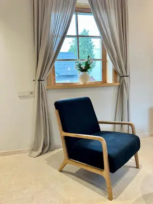 a blue chair sitting in front of a window at Poeto Namas Art in Anykščiai