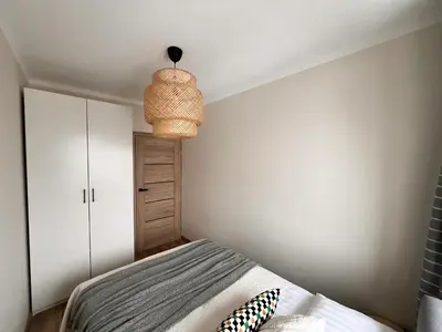 a bedroom with a bed and a light fixture at AL Apartment, Central & Cozy in Panevėžys