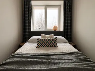 a bedroom with a large bed with a window at AL Apartment, Central & Cozy in Panevėžys