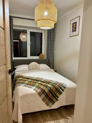 a bedroom with two beds and a chandelier at AL Apartment, Central & Cozy in Panevėžys