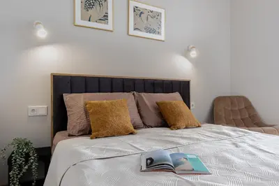 a bedroom with a bed with two books on it at Amber Apartment Free Parking - Self Check In in Vilnius