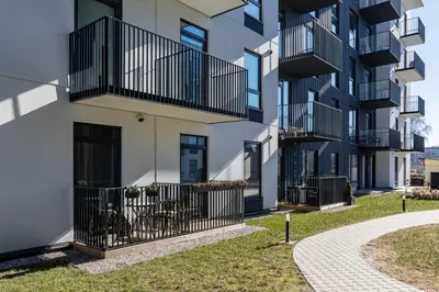 an apartment building with balconies and a sidewalk at Amber Apartment Free Parking - Self Check In in Vilnius