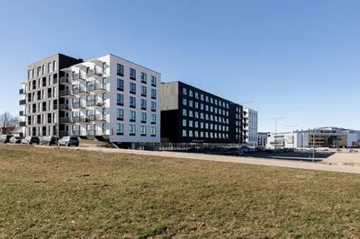 two tall buildings on a street with a grass field at Amber Apartment Free Parking - Self Check In in Vilnius
