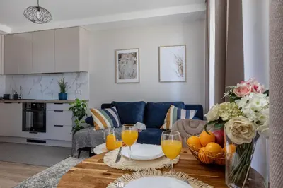 a living room with a table with glasses of orange juice at Amber Apartment Free Parking - Self Check In in Vilnius