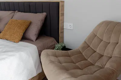 a bedroom with a bed and a chair next to it at Amber Apartment Free Parking - Self Check In in Vilnius