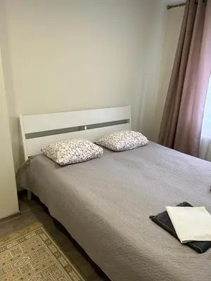 a bedroom with a bed with two pillows on it at White apartment in Druskininkai