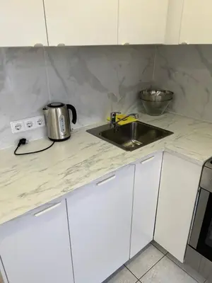 a kitchen counter with a sink and a microwave at White apartment in Druskininkai