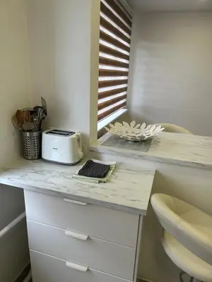 a kitchen counter with a toaster and a laptop on it at White apartment in Druskininkai