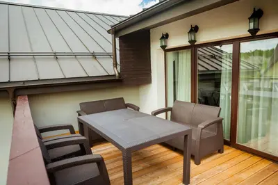 a patio with a table and chairs on a balcony at Vila Nikolas in Druskininkai