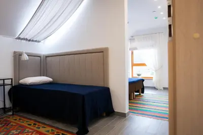 a bedroom with a bed with a blue blanket at Vila Nikolas in Druskininkai