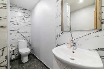 a white bathroom with a sink and a toilet at Fox studio apartment in Šiauliai