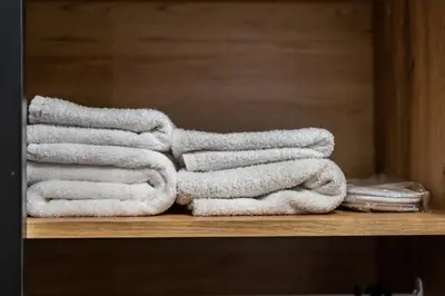 a pile of towels sitting on a shelf at Fox studio apartment in Šiauliai
